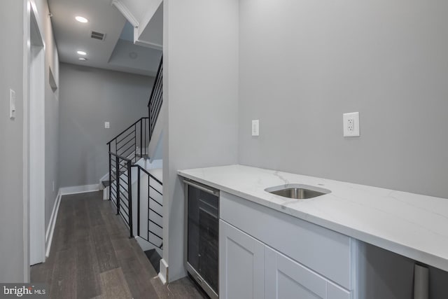 bar featuring white cabinets, dark hardwood / wood-style floors, light stone counters, and wine cooler