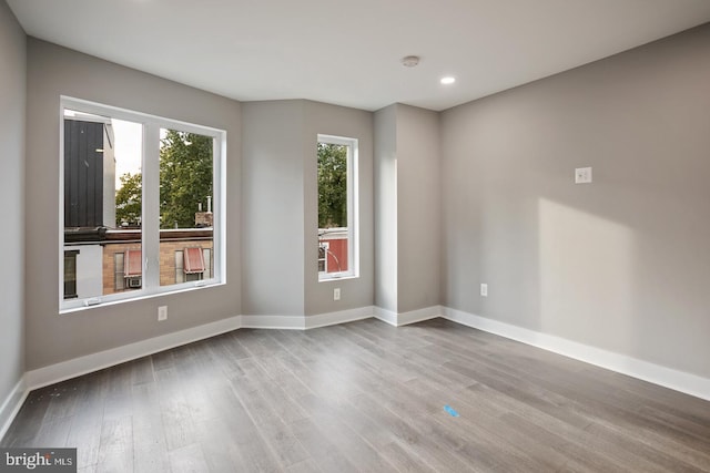 unfurnished room with hardwood / wood-style flooring