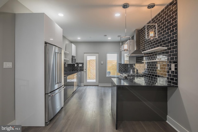 kitchen featuring dark hardwood / wood-style floors, stainless steel appliances, hanging light fixtures, and white cabinets