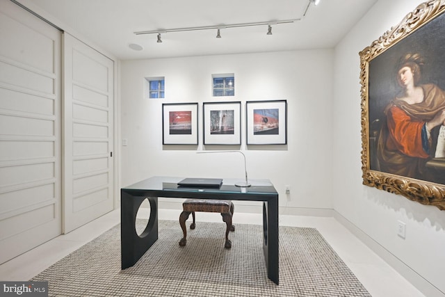 office space featuring track lighting and light tile patterned flooring