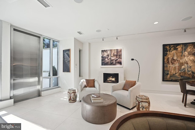 tiled living room featuring track lighting