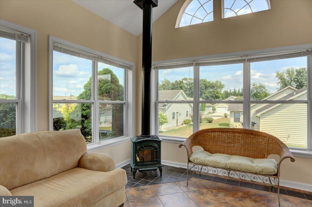 sunroom with vaulted ceiling and a wood stove