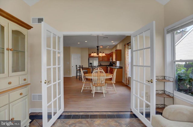 dining area with french doors and a chandelier