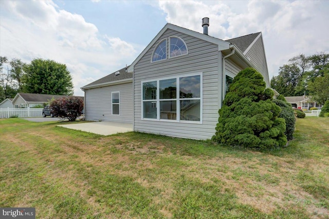 back of property featuring a patio area and a lawn