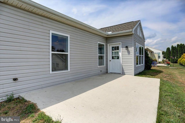 property entrance featuring a patio area and a lawn