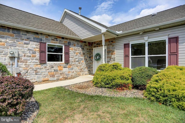 doorway to property with a lawn