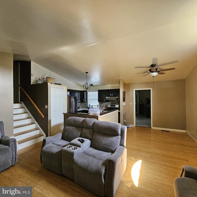 living room featuring lofted ceiling, ceiling fan, and light wood-type flooring