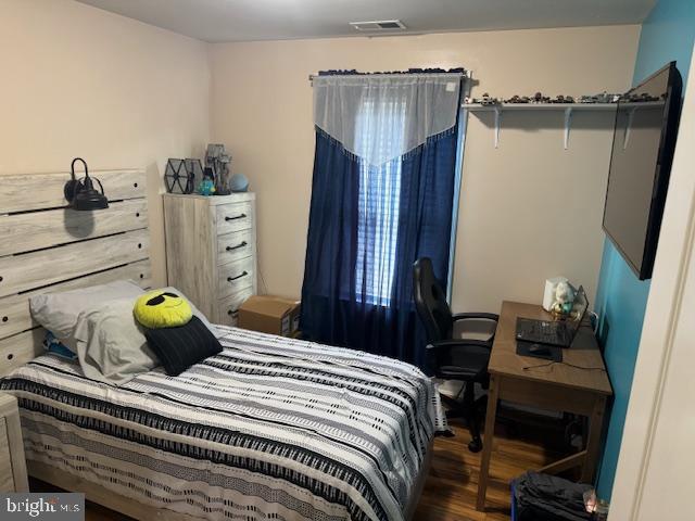 bedroom with dark hardwood / wood-style flooring