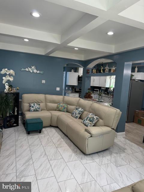 living room featuring beam ceiling and coffered ceiling