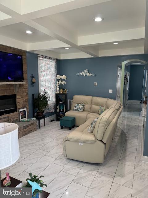 living room with a fireplace and beamed ceiling