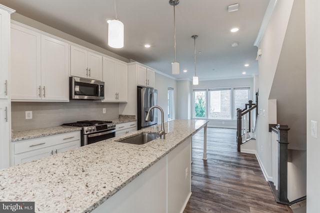 kitchen with white cabinetry, stainless steel appliances, and hanging light fixtures