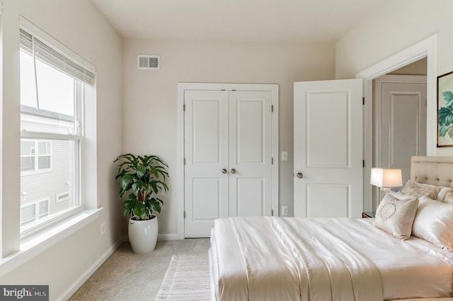 bedroom featuring light carpet and a closet