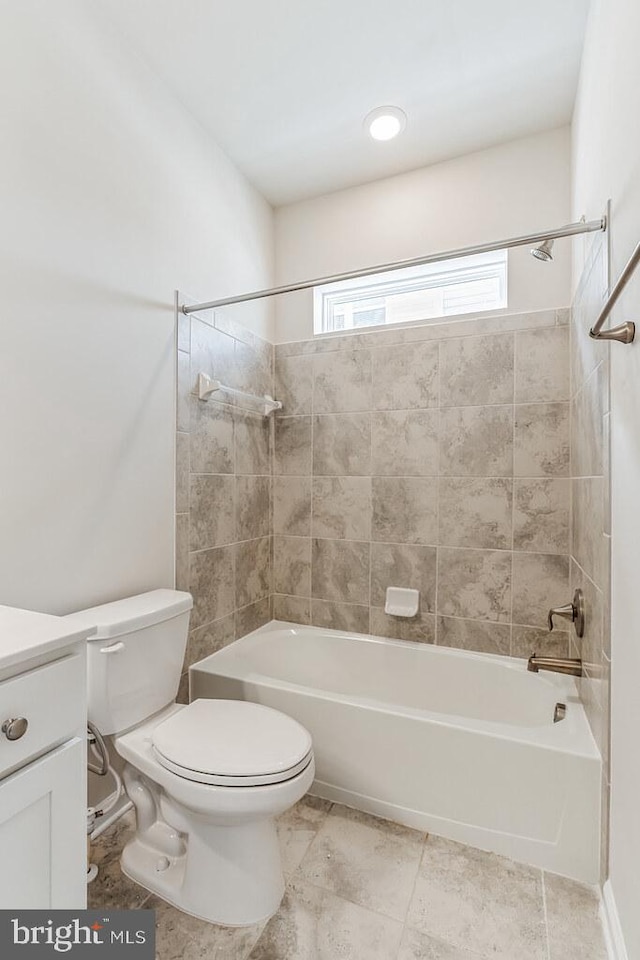 full bathroom with vanity, tiled shower / bath combo, and toilet