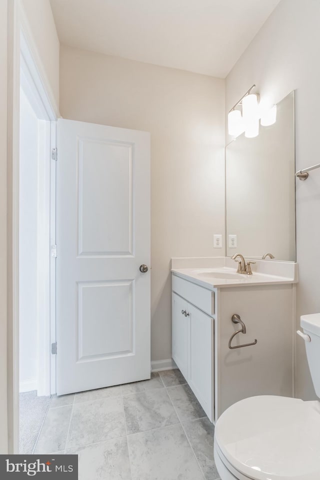 bathroom with tile patterned flooring, vanity, and toilet