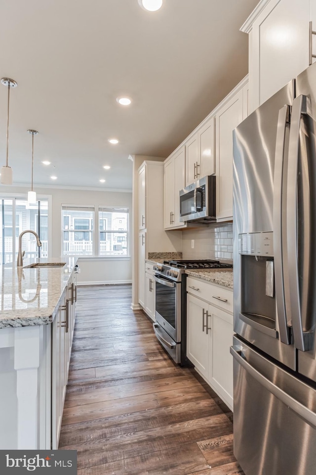 kitchen with white cabinetry, sink, pendant lighting, decorative backsplash, and appliances with stainless steel finishes