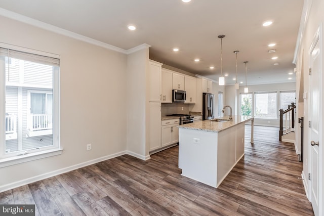 kitchen featuring white cabinetry, a kitchen island with sink, pendant lighting, and stainless steel appliances