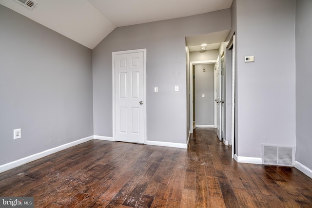 unfurnished room featuring vaulted ceiling and dark wood-type flooring