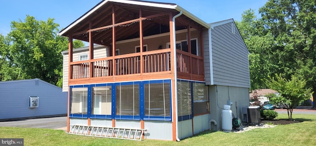 back of property featuring central air condition unit and a yard