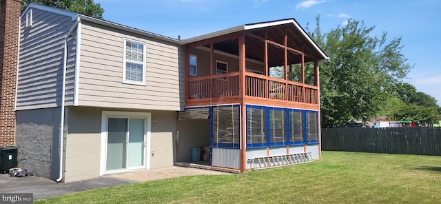 back of house featuring a balcony and a yard