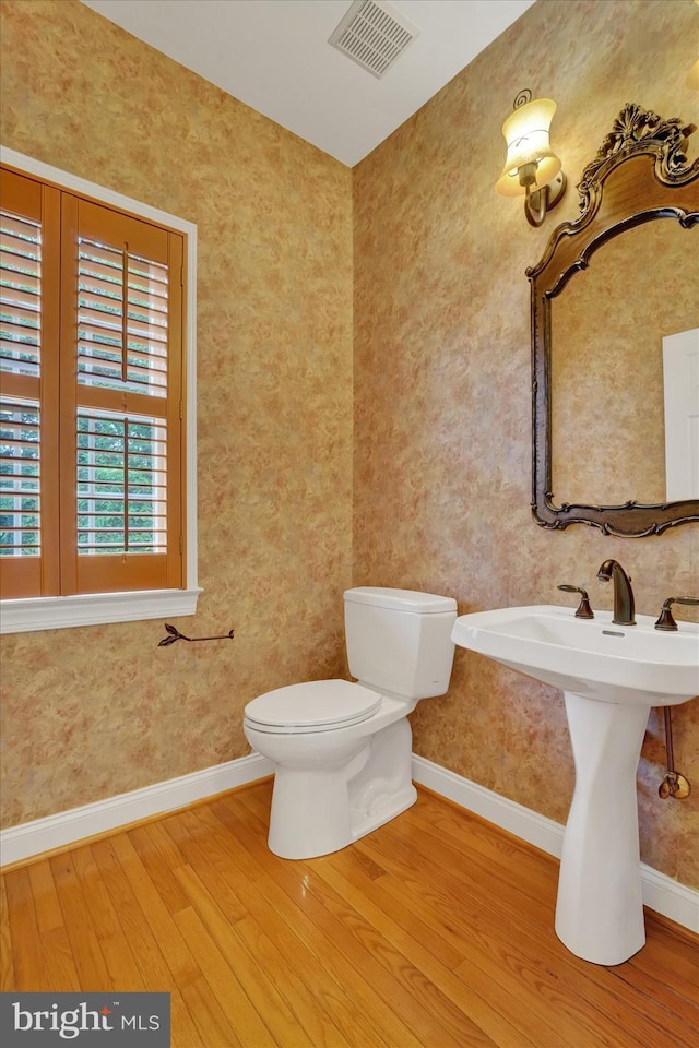 bathroom with toilet and hardwood / wood-style floors