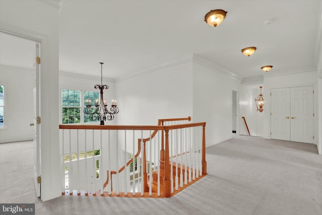 corridor with light carpet, ornamental molding, and a notable chandelier