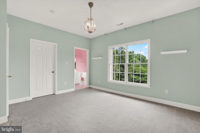 unfurnished bedroom with carpet flooring and a chandelier