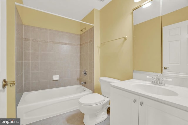 full bathroom with toilet, tile patterned flooring, tiled shower / bath, and vanity