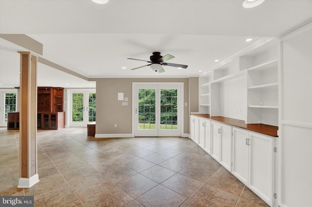 unfurnished living room featuring french doors, ceiling fan, ornamental molding, and built in features