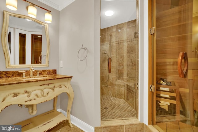 bathroom featuring a shower with door, vanity, tile patterned floors, and crown molding