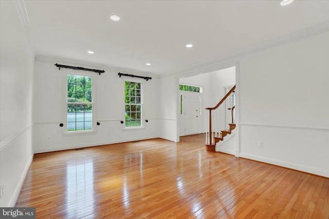 spare room with ornamental molding and light hardwood / wood-style flooring