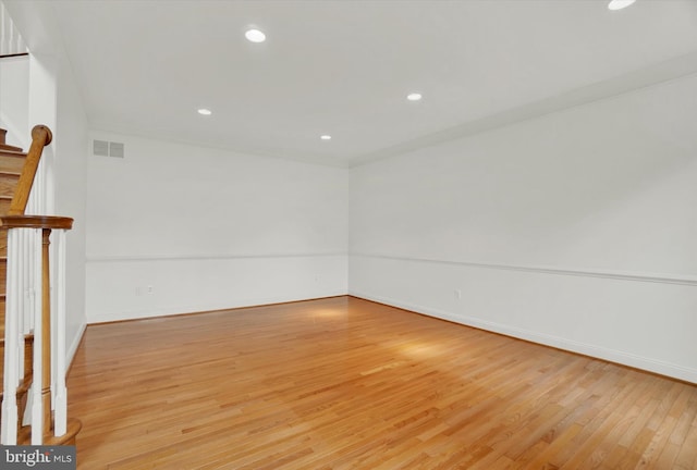 empty room with light hardwood / wood-style flooring and crown molding