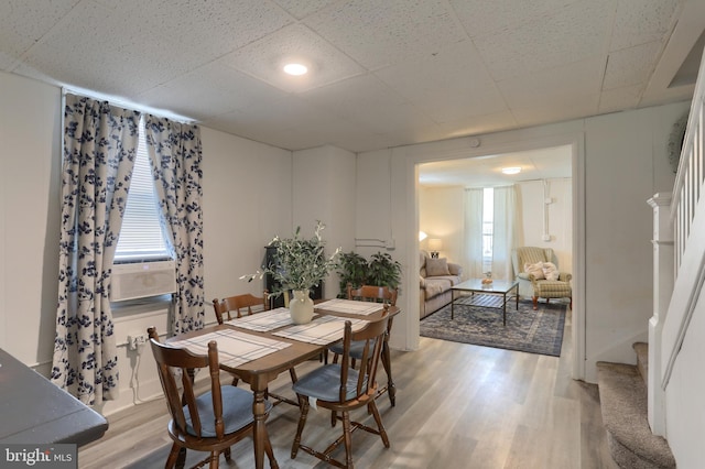 dining space with light hardwood / wood-style floors and cooling unit