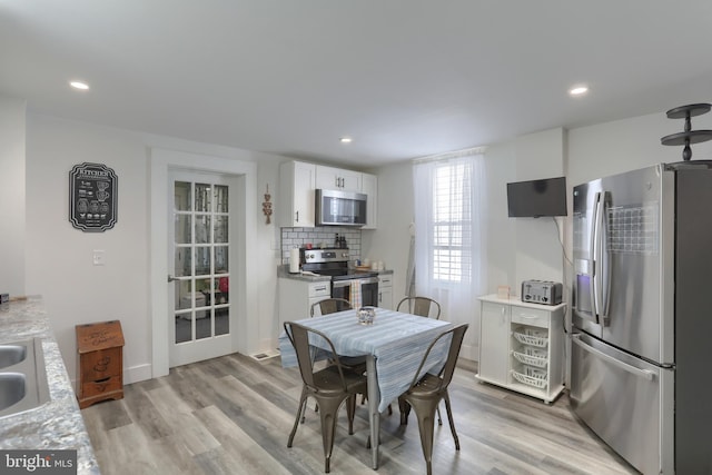 dining space with light wood-type flooring and sink