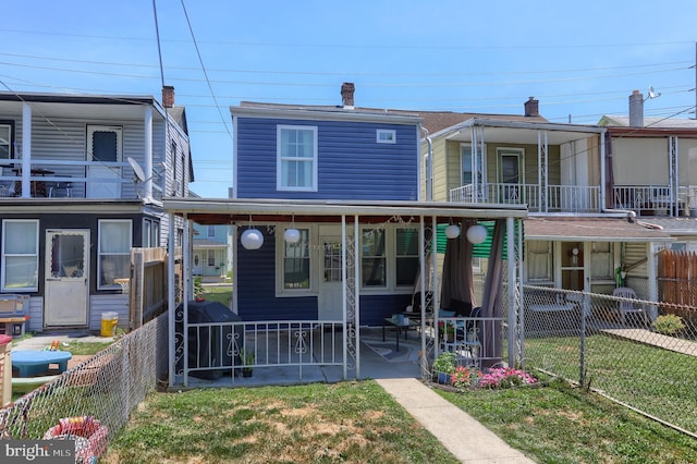 view of front of property with a balcony and a front yard