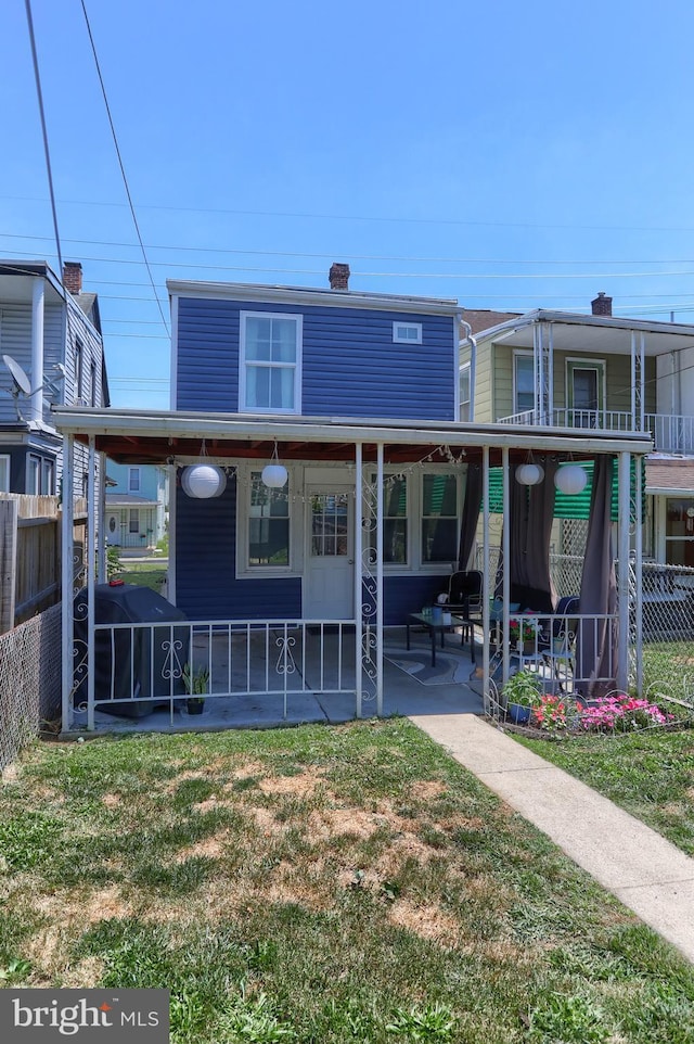 back of house with a patio area and a yard