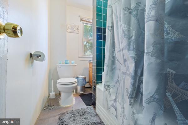 bathroom featuring curtained shower and toilet