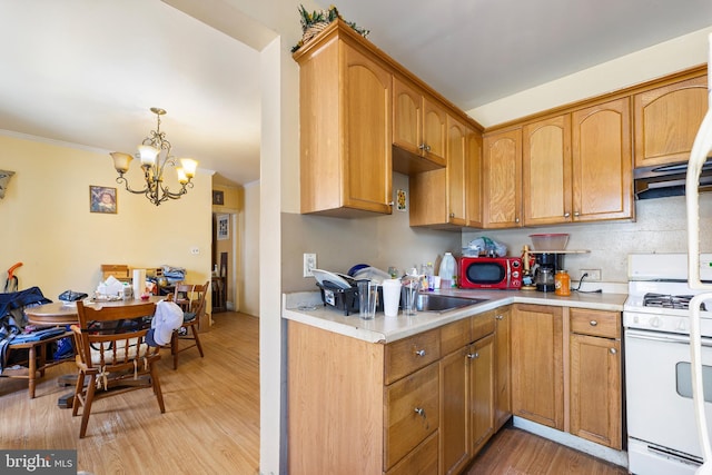 kitchen with white range, sink, light hardwood / wood-style flooring, decorative light fixtures, and a chandelier