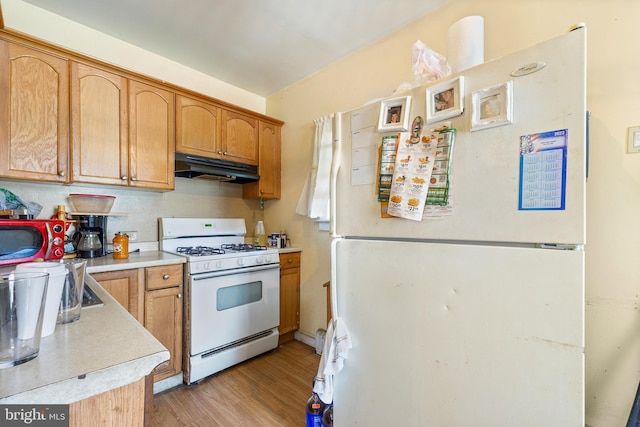 kitchen featuring white appliances and light hardwood / wood-style floors