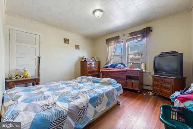 bedroom with dark hardwood / wood-style floors and crown molding