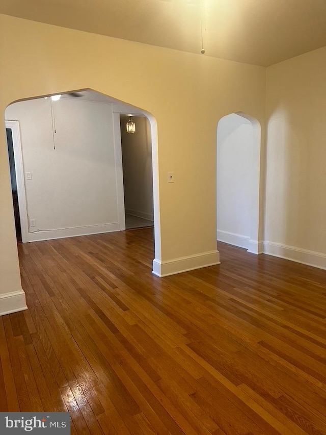 unfurnished room with dark hardwood / wood-style floors and lofted ceiling