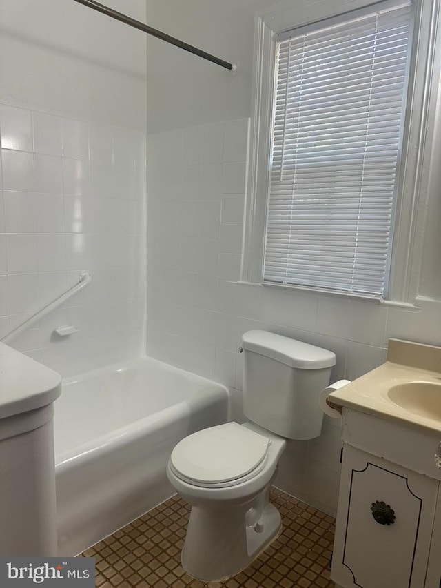 full bathroom with tile patterned flooring, tile walls, toilet, and vanity