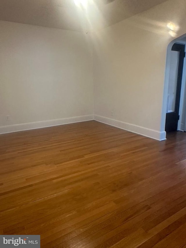 unfurnished room featuring dark wood-type flooring