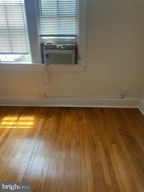 unfurnished room featuring cooling unit and hardwood / wood-style flooring