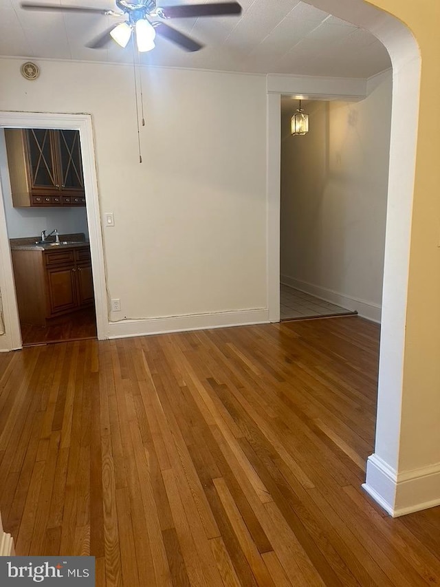 unfurnished room with hardwood / wood-style flooring, sink, and ceiling fan