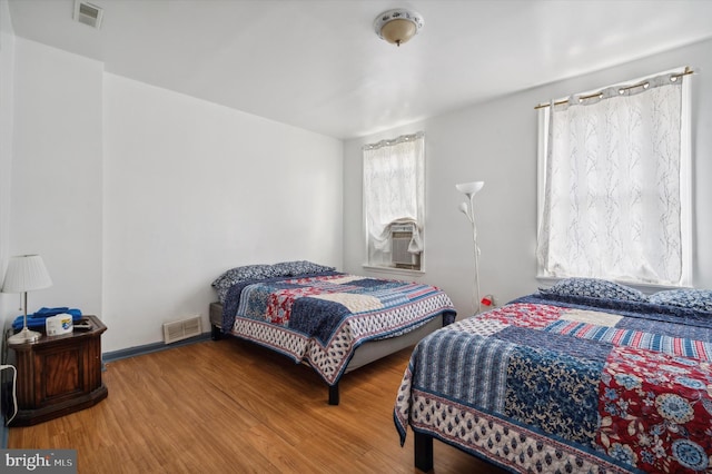 bedroom featuring hardwood / wood-style floors and cooling unit