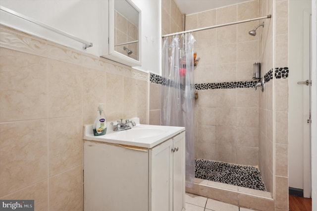 bathroom featuring vanity, tile walls, a shower with shower curtain, and tile patterned flooring