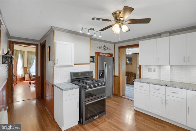 kitchen featuring stainless steel appliances, light hardwood / wood-style floors, and ornamental molding