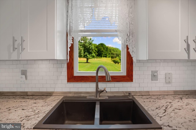 kitchen featuring sink, white cabinetry, and decorative backsplash