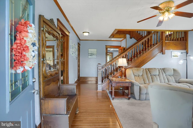 living room featuring crown molding, ceiling fan, and carpet flooring