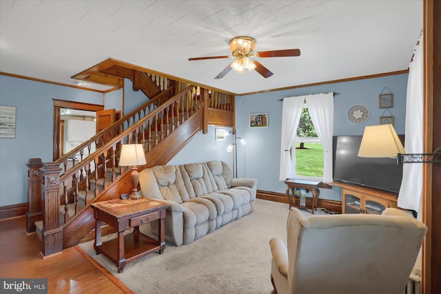 living room featuring hardwood / wood-style floors, ornamental molding, and ceiling fan